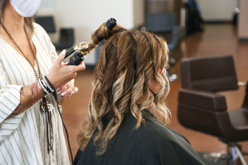women with highlight hair having her hair curled